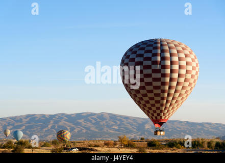 I palloni ad aria calda atterra dopo un volo sulla valle della Cappadocia al mattino. Nevsehir provincia. La Turchia. Foto Stock