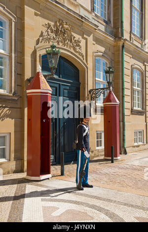 Royal Guard permanente al garitta alle porte del Palazzo Reale di Amalienborg nel centro di Copenhagen, Danimarca. Foto Stock