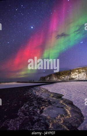 Luci del nord oltre la spiaggia nera vicino a Vík paesino nel sud dell'Islanda Foto Stock
