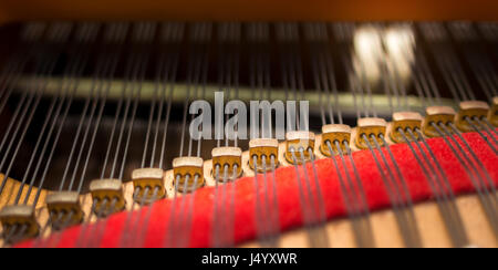 Pianoforte agraffes closeup, con stringhe e due testa di martello in azione, il fuoco selettivo. Foto Stock