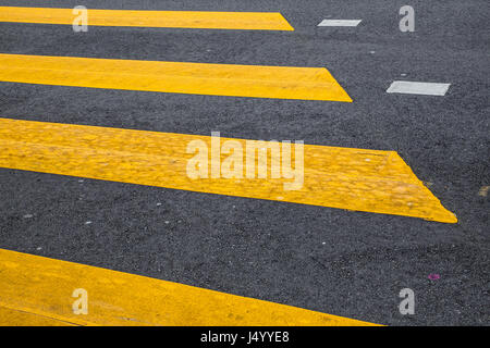 Verniciato giallo crosswalk strada marcature di linea con la vettura in movimento in background Foto Stock