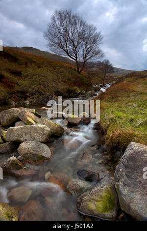 Una stretta e lunga esposizione vista del flusso roccioso in corrispondenza della testa di Seatoller passano in inglese il Parco Nazionale del Distretto dei Laghi Foto Stock