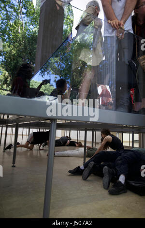 (170515) -- Venezia, 15 maggio 2017 (Xinhua) -- artisti eseguono presso il padiglione della Germania durante la 57ª Biennale di arte a Venezia, Italia, il 13 maggio 2017. Coreografo tedesco Anne Imhof si è aggiudicato il Leone dâ Oro per la migliore partecipazione nazionale alla 57ma Biennale di arte a Venezia. Per il suo lavoro intitolato 'Faust' dopo il classico tedesco racconto di un uomo che vende la sua anima al diavolo in cambio di un numero illimitato di conoscenza e di potere Imhof riempito il bianco, padiglione rettangolare di Germania con intersecante le pareti di vetro e pavimenti e poi posto un gruppo di artisti nel seminterrato. I visitatori osservano il Foto Stock