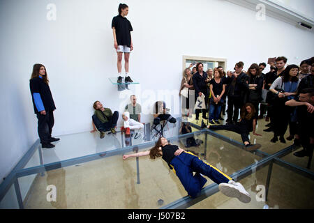 (170515) -- Venezia, 15 maggio 2017 (Xinhua) -- artisti eseguono presso il padiglione della Germania durante la 57ª Biennale di arte a Venezia, Italia, il 13 maggio 2017. Coreografo tedesco Anne Imhof si è aggiudicato il Leone dâ Oro per la migliore partecipazione nazionale alla 57ma Biennale di arte a Venezia. Per il suo lavoro intitolato 'Faust' dopo il classico tedesco racconto di un uomo che vende la sua anima al diavolo in cambio di un numero illimitato di conoscenza e di potere Imhof riempito il bianco, padiglione rettangolare di Germania con intersecante le pareti di vetro e pavimenti e poi posto un gruppo di artisti nel seminterrato. I visitatori osservano il Foto Stock