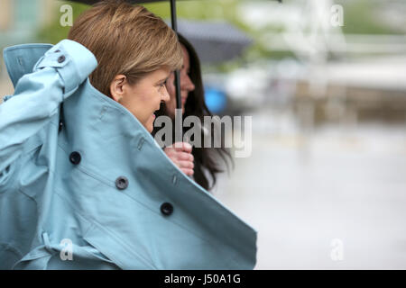 Hamilton, Scotland, Regno Unito. 15 Maggio, 2017. Nicola Storione SNP MSP Leader che fissa il suo sovrarivestimento come piove weathers il 2017 elezione generale campaign trail nella città di Hamilton in Lanark e Hamilton est circoscrizione. Credito: Allan Milligan/Alamy Live News Foto Stock