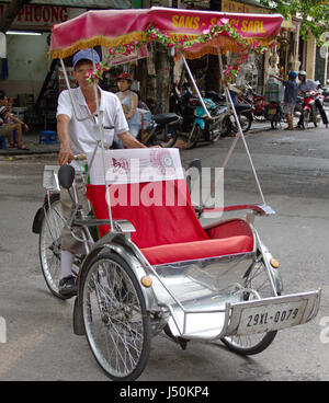 Un driver cyclo cercando personalizzato nel vecchio quartiere, Hanoi, Vietnam Foto Stock