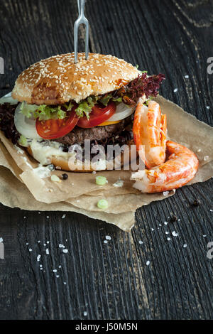 Freschi e deliziosi in casa surf and turf burger sul tavolo di legno Foto Stock