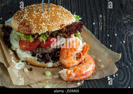 Freschi e deliziosi in casa surf and turf burger sul tavolo di legno Foto Stock