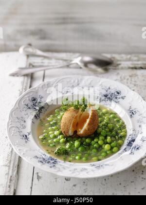Fresca zuppa di piselli con uovo fritto Foto Stock