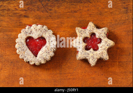 Biscotti frollini con marmellata il deposito su sfondo di legno Foto Stock