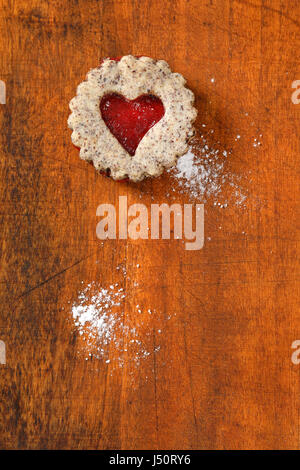 Biscotti frollini con marmellata il deposito su sfondo di legno Foto Stock