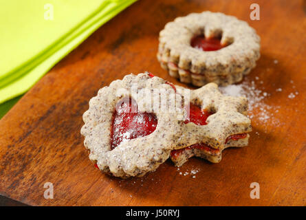 Biscotti frollini con marmellata il deposito su sfondo di legno Foto Stock