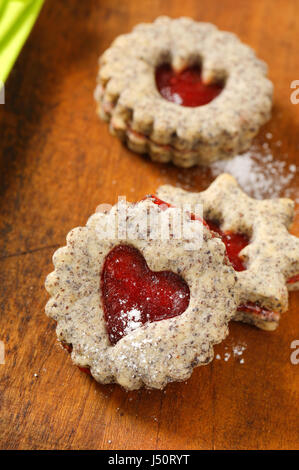 Biscotti frollini con marmellata il deposito su sfondo di legno Foto Stock