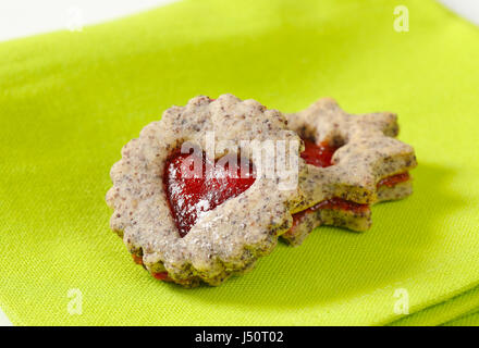 Biscotti frollini con marmellata il deposito su sfondo verde Foto Stock