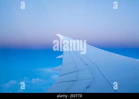 Ala di un aeroplano che vola sopra le nuvole Foto Stock