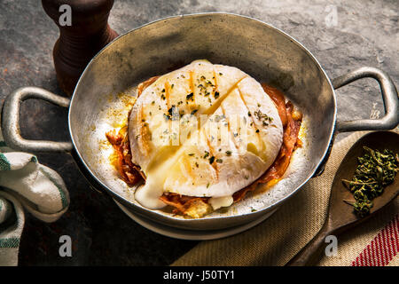 Delizioso formaggio italiano tomino con pancetta grigliate di primo piano Foto Stock