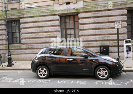 La Nissan Leaf auto elettrica di essere ricaricato quando è parcheggiata nello spazio riservato per i veicoli elettrici solo in St Margaret, Birmingham, Regno Unito Foto Stock