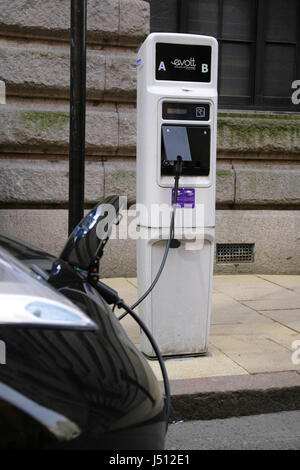 La Nissan Leaf auto elettrica di essere ricaricato quando è parcheggiata nello spazio riservato per i veicoli elettrici solo in St Margaret, Birmingham, Regno Unito Foto Stock