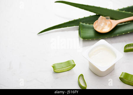 Aloe vera yogurt con foglie fresche su un tavolo di legno Foto Stock