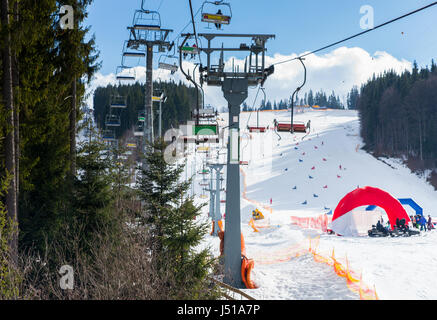 Impianti di risalita con sedi di andare oltre la montagna e percorsi per sci e snowboard in una località sciistica nel periodo invernale Foto Stock