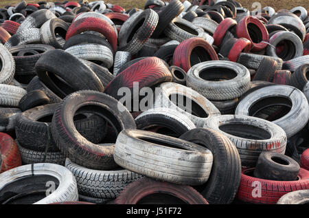 Varietà di rosso bianco e nero dei rifiuti pneumatici auto accatastati in una grande pila Foto Stock