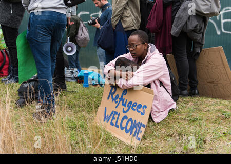 Bedford, Regno Unito. 15 Maggio, 2017. Un manifestante tiene un cartello che recita "rifugiati Benvenuti', a una protesta contro il Regno Unito in materia di immigrazione la politica di detenzione. Centinaia di contestatori dimostravano fuori il Yarl del centro di legno, calci e colpendo le recinzioni perimetrali, e la possibilità di chiamare il centro di spegnimento. Credito: Giacobbe Sacks-Jones/Alamy Live News. Foto Stock