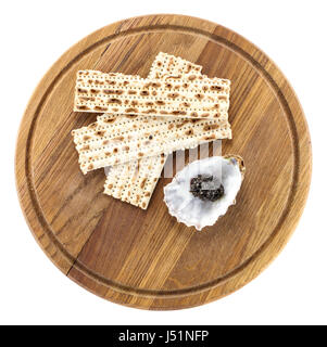 Nero caviale di storione e matzah sul tagliere, vista da sopra. Con il tracciato di ritaglio. Foto Stock