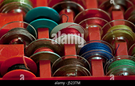 Bobine di filo per cucitura a macchina nella casella vicino a Foto Stock