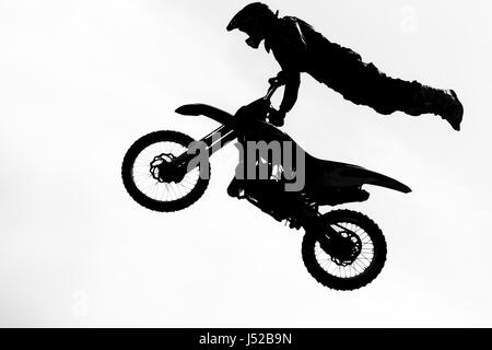 Jumping motorcircle rider silhouette su sfondo bianco. Foto Stock