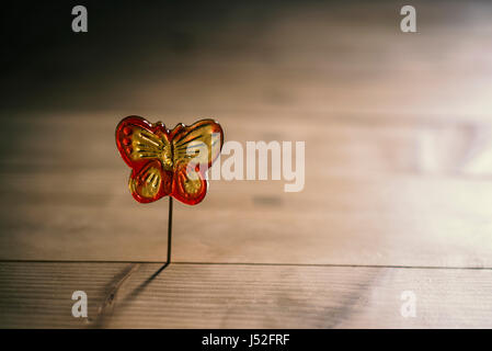 Fragranti lecca-lecca a forma di farfalla su un bastone, illuminazione Foto Stock