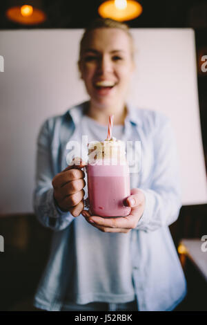 Felice ragazza è azienda stilizzata mason jar tazza di caffè rosa con marshmallow e decorazione. Milk Shake, cocktail. Unicorn caffè, unicorn cibo. Soft Foto Stock