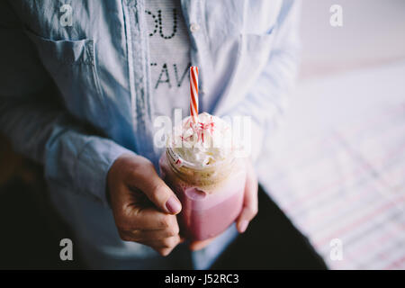 Ragazza è azienda stilizzata mason jar tazza di caffè rosa con crema, marshmallow e decorazione. Milk Shake, cocktail. Unicorn caffè, unicorn cibo. Clos Foto Stock