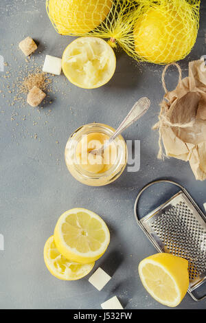 Vasetto di casalinghe cagliata di limone con cucchiaio, interi e fette