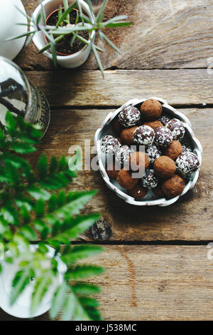 Tartufi di cioccolato coperto in dadi su un tavolo di legno. Foto Stock