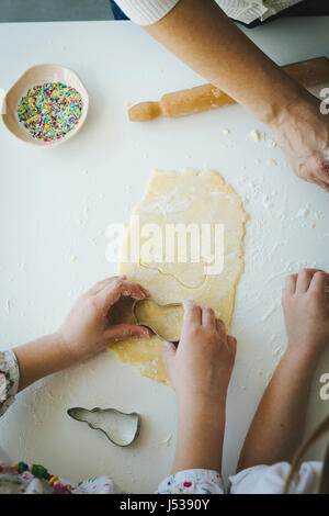 La madre e le figlie rendendo i cookie di Pasqua Foto Stock