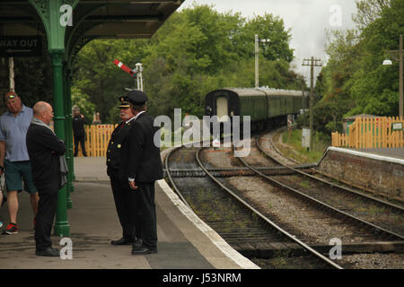 Swanage, Regno Unito - 12 Maggio: Swanage guardie ferroviaria e la stazione master chat sulla piattaforma a Corfe Castle stazione dopo la partenza delle 14.00 ore di treno a Norden. Vista generale di ​the cittadina balneare di ​Swanage​ nel Dorset, Inghilterra.​ © David Mbiyu/Alamy Live News Foto Stock