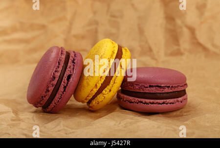 Gruppo di più colorato fresco Francese tradizionale pasticceria amaretto cookies (macarons, maccheroni) su carta marrone pergamena sfondo, chiudere fino a basso ang Foto Stock