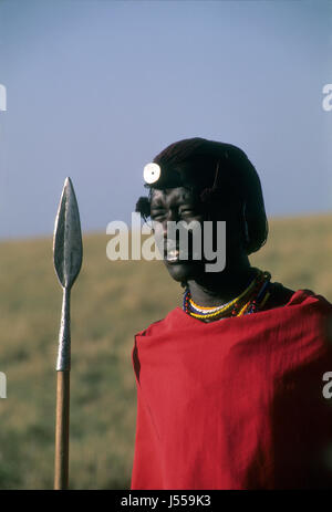 Guerriero Masai con lancia su pianure africane vicino al fiume Talek, Masai Mara Game Reserve, Kenya Foto Stock