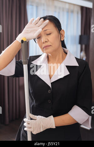 Lavoro duro Asian cameriera chiudendo gli occhi Foto Stock