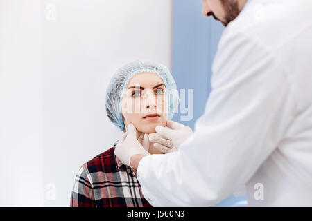 Grave giovane donna avente un appuntamento con un chirurgo di plastica Foto Stock