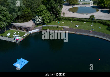 Amburgo, Germania. Il 17 maggio 2017. Bagnanti giacciono sul prato presso la piscina naturale città Parco Lago ad Amburgo, Germania, 17 maggio 2017. La società Baderland ha annunciato che le piscine di Billstedt e il Kaifu-piscina aperto le loro porte ai visitatori lungo con la piscina naturale. Foto: Axel Heimken/dpa/Alamy Live News Foto Stock