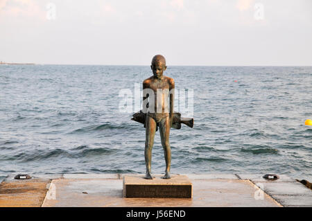 Statua di un ragazzo con un pesce sulla riva del Mare Mediterraneo da Giota Ioannidou, Paphos, Cipro Foto Stock