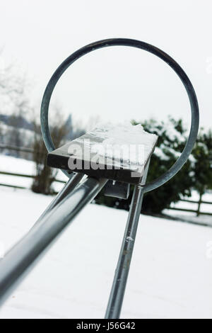 Svuotare altalena con neve su di esso Foto Stock