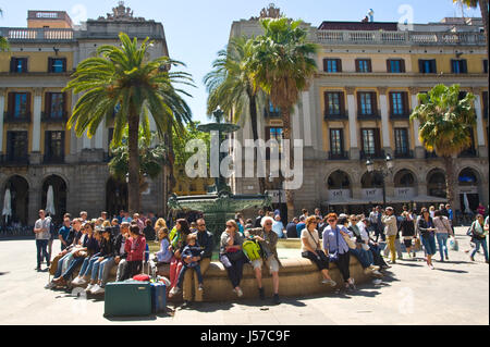 I turisti con valigie seduti intorno a fontana sulla piazza di Barcellona Spagna ES UE Foto Stock