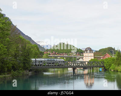 La svizzera BLS Interlakena treno andando a Interlaken Ost oltre il fiume Aare tra i due laghi di Brienz e di Thun nell Oberland bernese Foto Stock