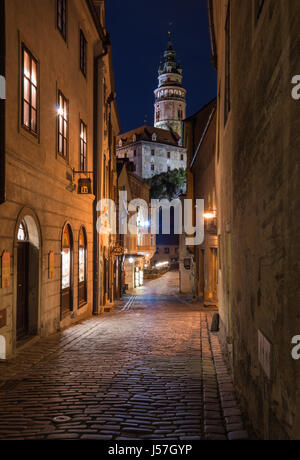Czesky Krumlov old town street view con la torre del castello di notte, Repubblica Ceca. Foto Stock
