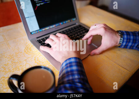 Primo piano di imprenditore è keyboarding sui portatili net-libro. Foto Stock