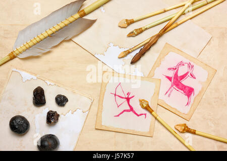 Nostalgic vintage still life with hunting drawings, primitive arrows and hematite lumps over aged paper sheets Foto Stock