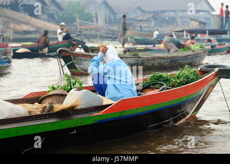 Indonesia, Borneo. Per il venditore sul mercato galleggiante in prossimità di Banjarmasin città sul fiume Martapura. Foto Stock