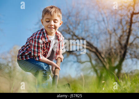 Adorabile ragazzo di scavare il suolo in primavera Foto Stock